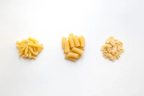 Three heaps of raw pasta with various shapes Stock Photos