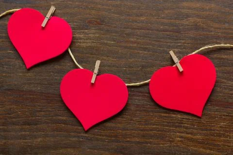 Three hearts attached to a rustic thread Stock Photos