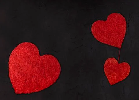 Three hearts of different size on a black background. valentines day concept Stock Photos