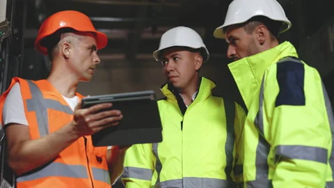 Three Heavy Industry Engineers and Worker Stand in Pipe Manufacturing Factory Stock Footage 194627138