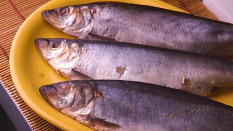 Three herring on a yellow dish Stock Footage 119300346