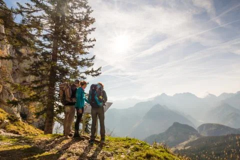 Three hikers looking at the map and admiring the view over the valley in Olseva, Stock Photos