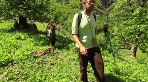 Three hikers-man and two women-walk toward camera in Himalayan field Stock Footage 66525170