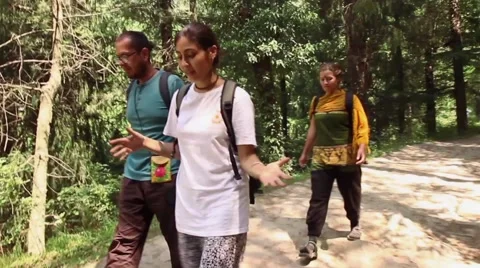 Three hikers- man and two women-walk a beautiful Himalayan path. Moving shot Stock Footage 66525177