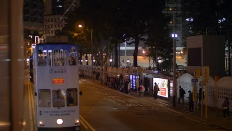 Three Hong Kong Trams Pass by at Nighttime 4k Stock Footage 123141923