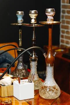 Three hookahs of different flavors stands on a table in a restaurant Stock Photos