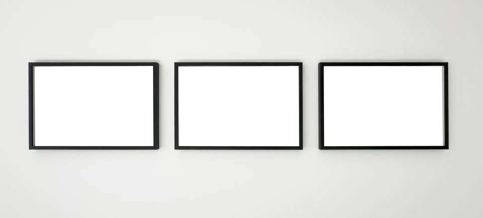 Three horizontal black picture frames hanging on a white wall, clean mockup f Stock Photos