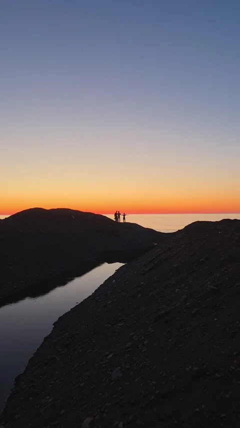 Three Human Silhouettes at Sunset Over the Black Sea Coast Stock Footage 336553331