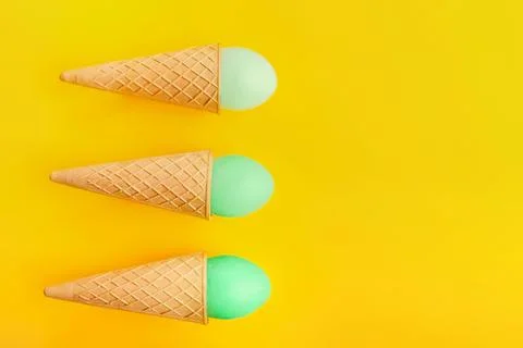 Three ice cream cones with mint green scoops on yellow background Stock Photos