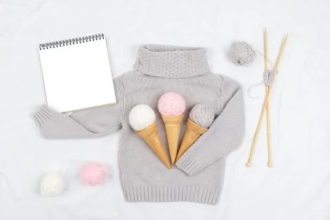 Three ice cream from yarn and waffle cones on a gray knitted sweater, wooden  Stock Photos