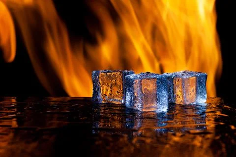 Three ice cubes against the background of fire, concept Stock Photos