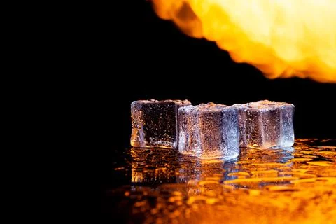 Three ice cubes against the background of fire, fire and ice, place under the Stock Photos