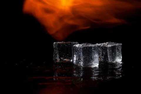 Three ice cubes and flames on a black background, place under the text Stock Photos