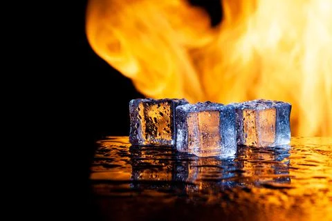 Three ice cubes and flames on a black background, place under the text Stock Photos