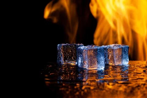 Three ice cubes and flames on a black background, place under the text Stock Photos