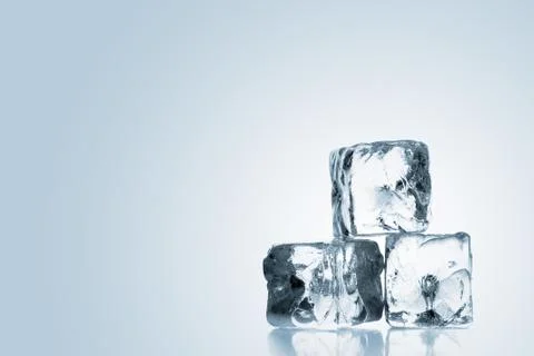 Three ice cubes stacked over blue gradient background Stock Photos