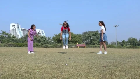 Three indian kid friends play skipping rope together in summer park, Childr.. 스톡 동영상 329092005