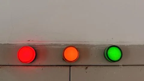Three Indicator Lights Red, Orange, and Green on Grey Industrial Panel Close  Foto stock