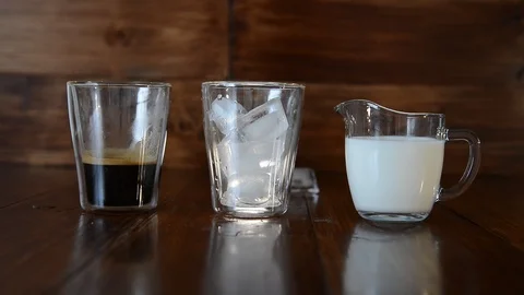 Three ingredients for coffee with ice are spread out over cups Stock Footage 94487748