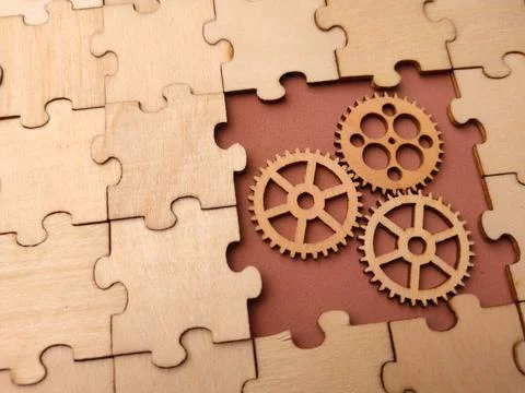 Three interlocking wooden gears placed within a missing section of a large .. 库存照片