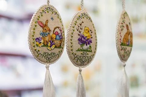 Three intricately embroidered Easter eggs, arranged diagonally against a ne.. Stock Photos