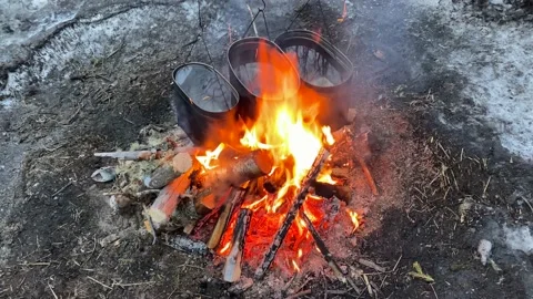 Three iron pots of water are hanging and heated over a large fire Stock-Footage 179345628
