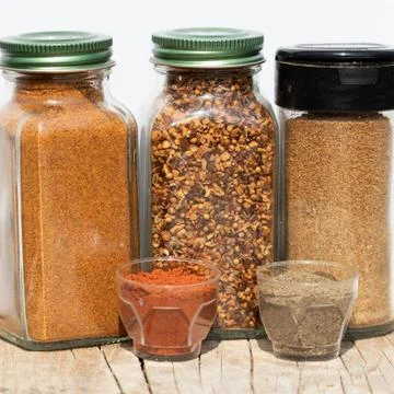 Three jars with spices of different grinding and two small bowls with red and Foto stock