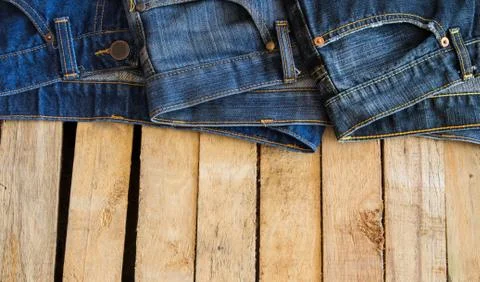 Three jeans with wood background Stock Photos