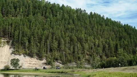 Three jeeps ride along the mountain road. Panorama. Mountain coniferous forest Stock Footage 73510618