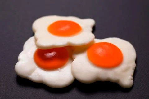 Three jelly eggs on a black background, close-up shot Stock Photos