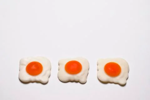 Three jelly-fried eggs lie at the bottom of a white background Stock Photos