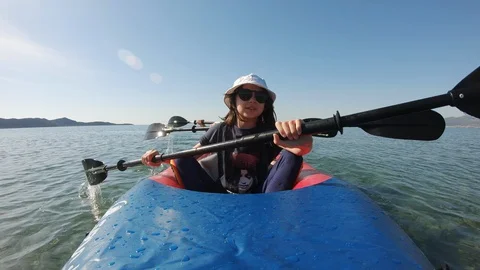Three Kayakers paddle fast on inflatable kayak in clear waters Video stock 130141818