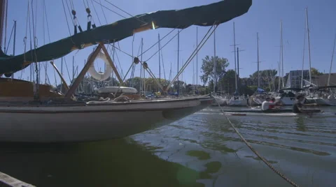 Three Kayakers Rowing Passed a Docked Boat Stock Footage 42907386