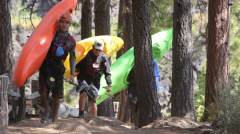 Three kayakers walk along path Stock Footage 61669918