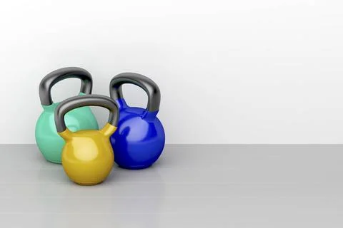 Three kettlebells Three kettlebells of different size on shiny gray floor ... Stock Photos