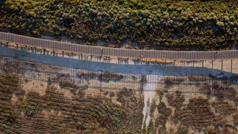 Three keyframes capture fence line cutting through arid hillsides Stock Footage 345225827