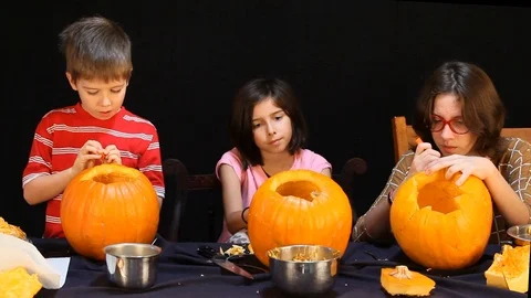 Three Kids Carving Pumpkins Stock Footage 97772648