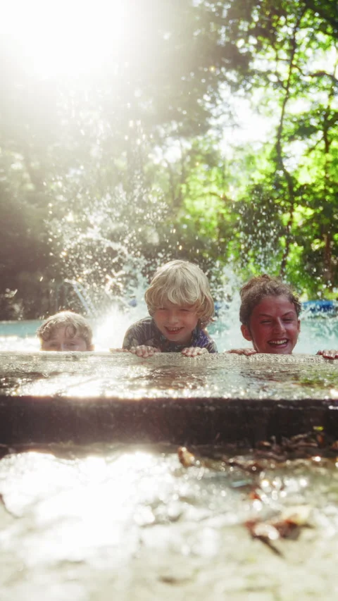 Three Kids Flutter Kicking The Water Making Splashes In The Pool Stock Footage 283629060