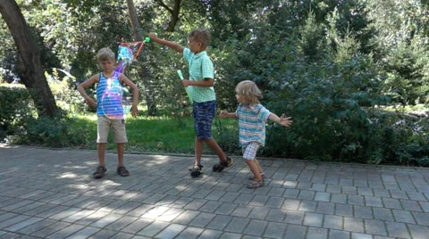 Three kids having fun with big soap bubbles Stock Footage 65828954