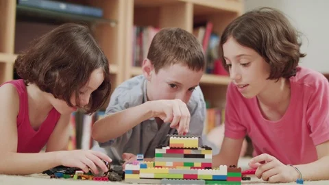 Three kids playing with lego bricks at home Stock Footage 95245528
