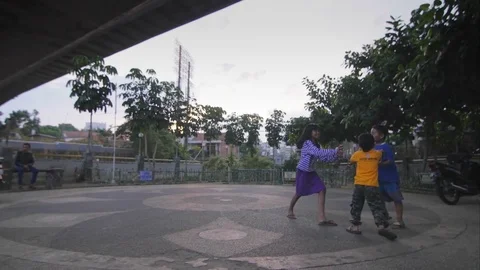 Three kids playing in a small square 스톡 동영상 75887581