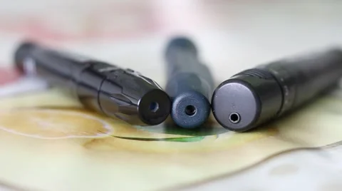 Three Lancing Devices used by Diabetes Lying on a Table Stock Footage 67471694