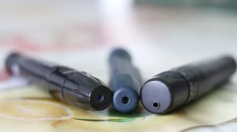 Three Lancing Devices used by Diabetes Lying on a Table Stock Footage 67471774