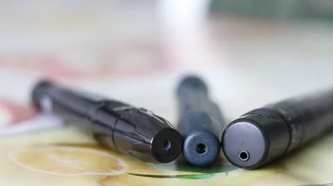 Three Lancing Devices used by Diabetes Lying on a Table Stock Footage 67471798