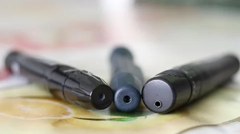 Three Lancing Devices used by Diabetes Lying on a Table Stock Footage 67471808