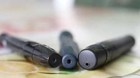 Three Lancing Devices used by Diabetes Lying on a Table Stock Footage 67471841