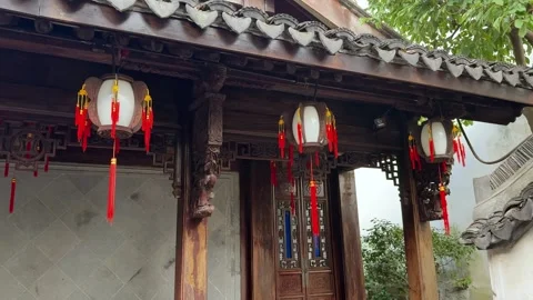 Three lanterns hang outside a building with intricate carvings and traditional Stock Footage 326387514