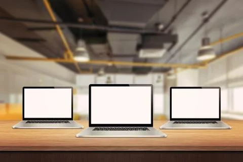 Three laptop devices on table in office interior Stock Photos