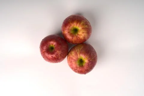 Three large apples lie on a white background. Stock Photos