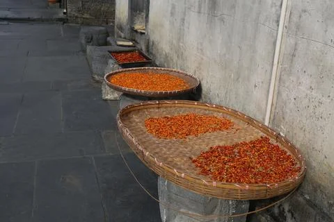 Three large bamboo baskets filled with dried red chili peppers, arranged on.. Stock Photos
